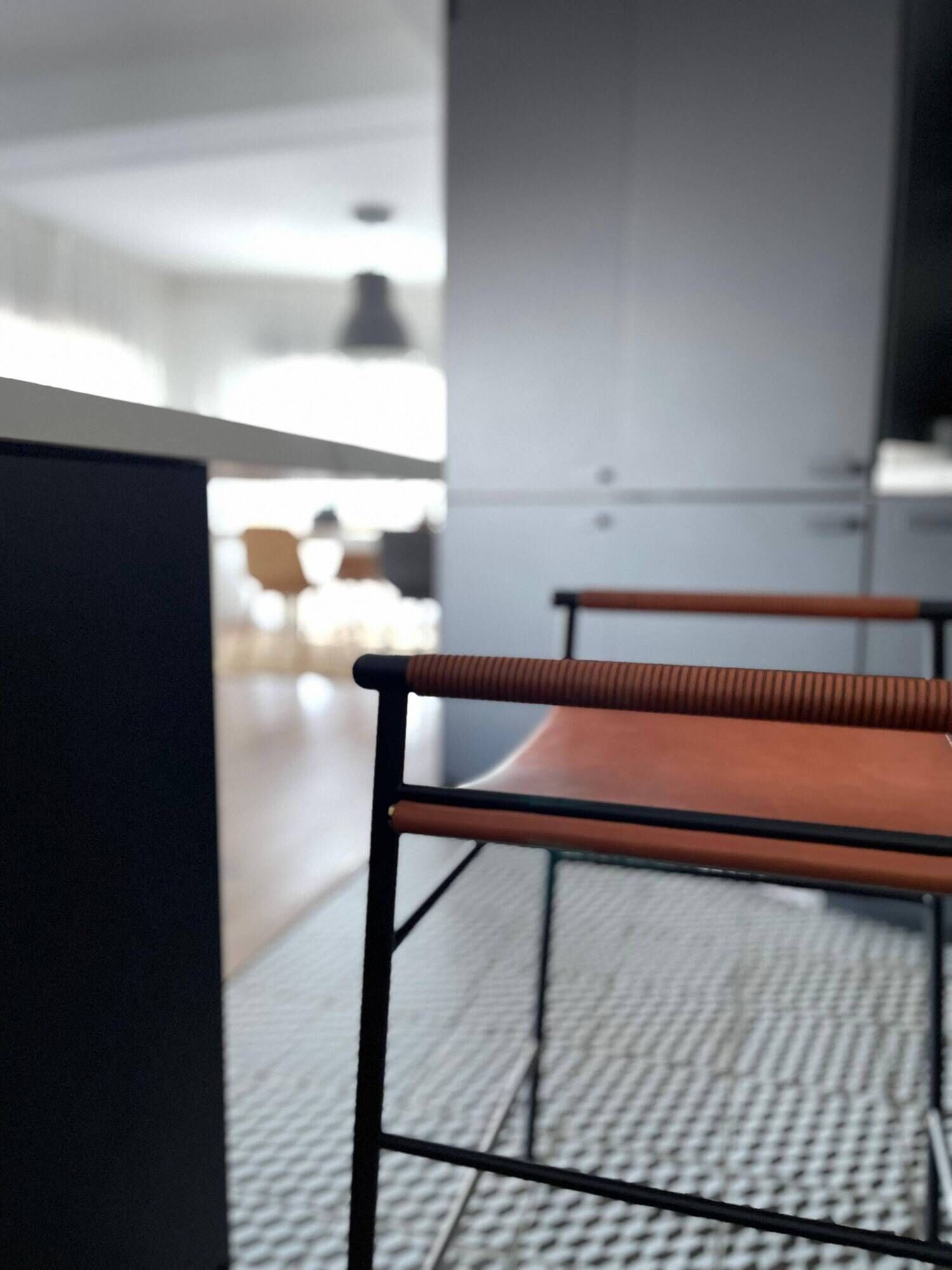 Set of 3 contemporary bar stools in natural brown leather and black rubber.