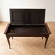 Antique wooden storage bench with red fabric.