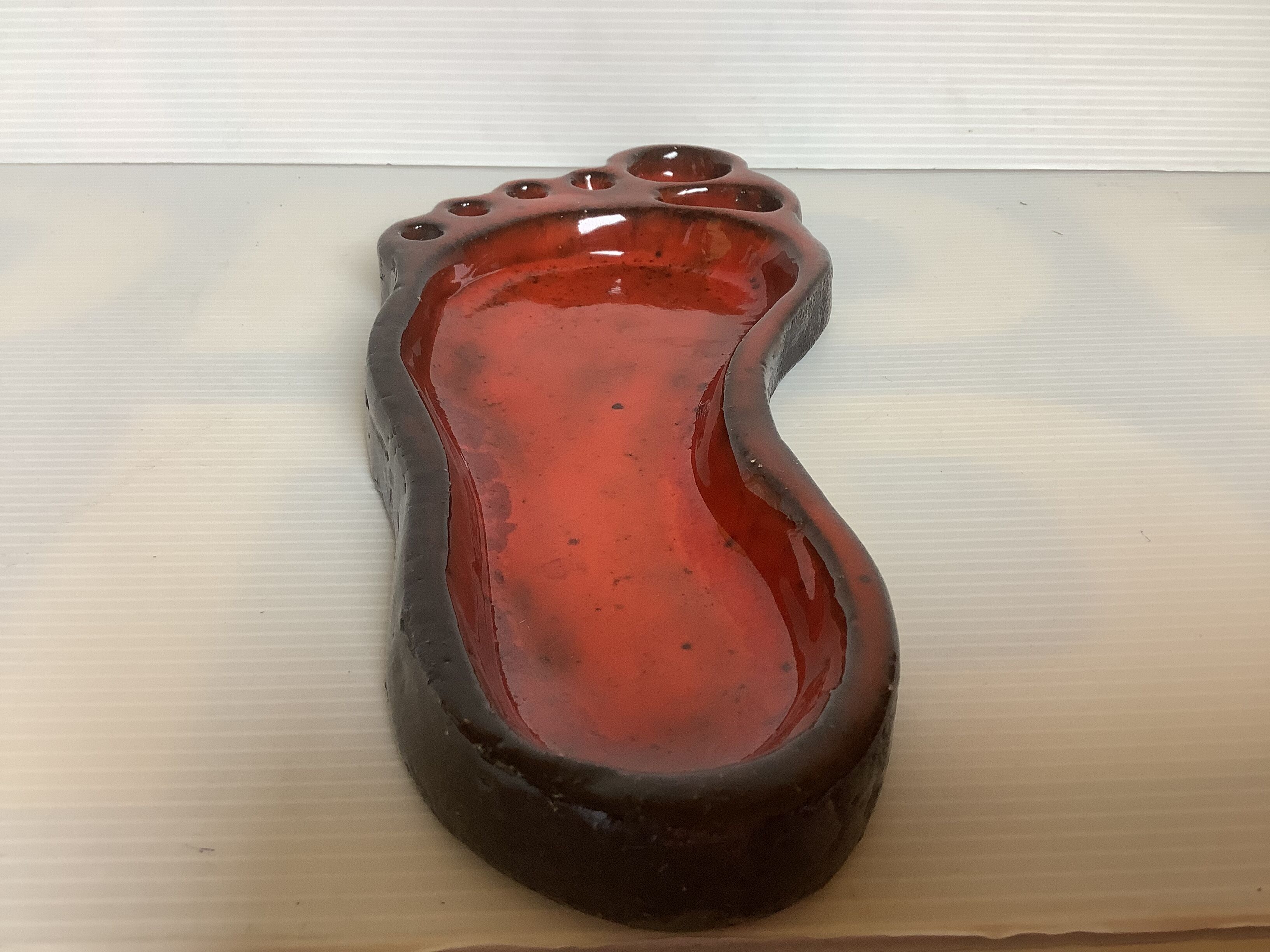 Red ceramic footprint catchall.