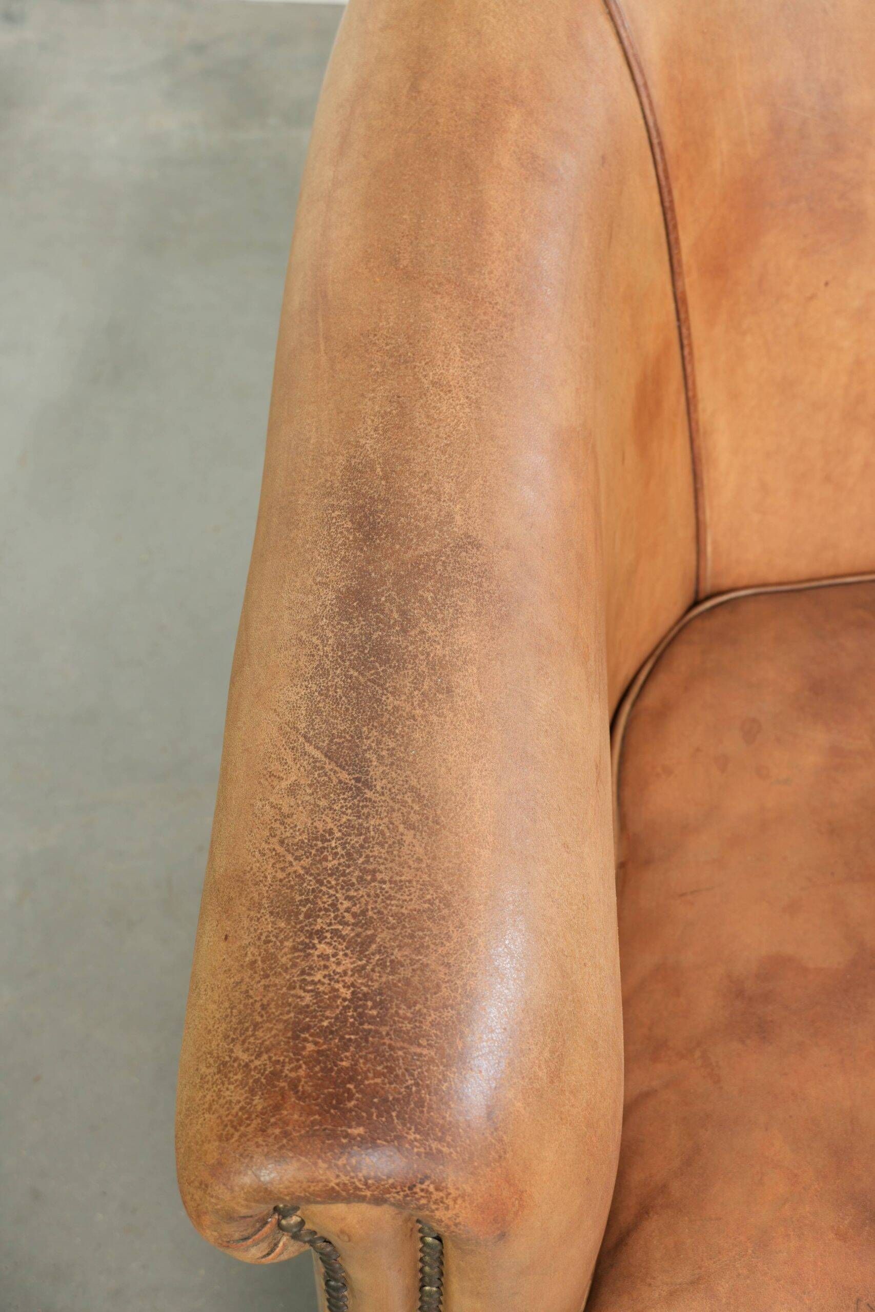 Fauteuil club en peau de mouton confortable de couleur cognac.
