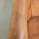 Fauteuil club en peau de mouton confortable de couleur cognac.