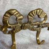 Two-hook coat rack with knot and ribbon in brass