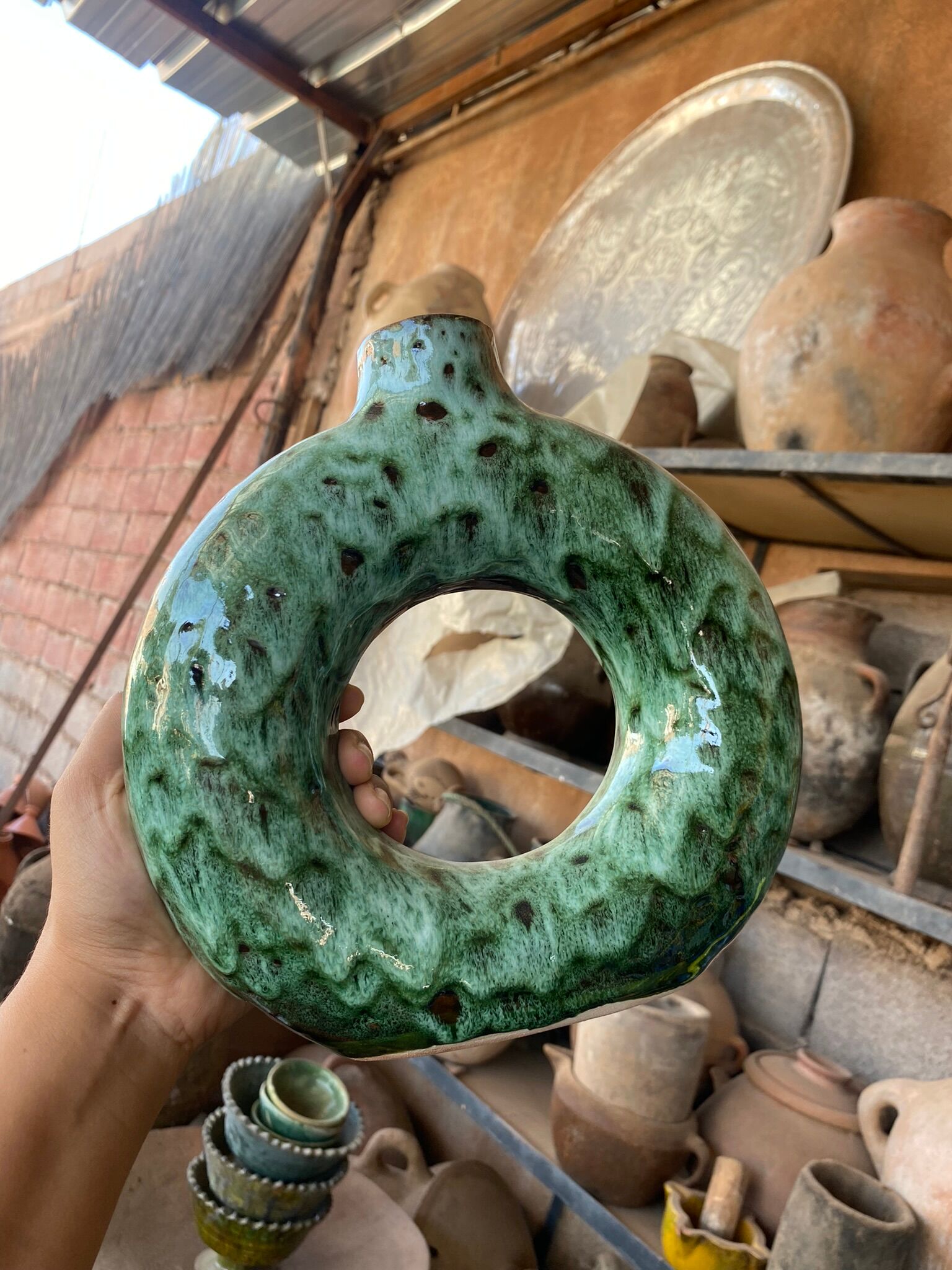 Handmade terracotta donut vase in light green terracotta