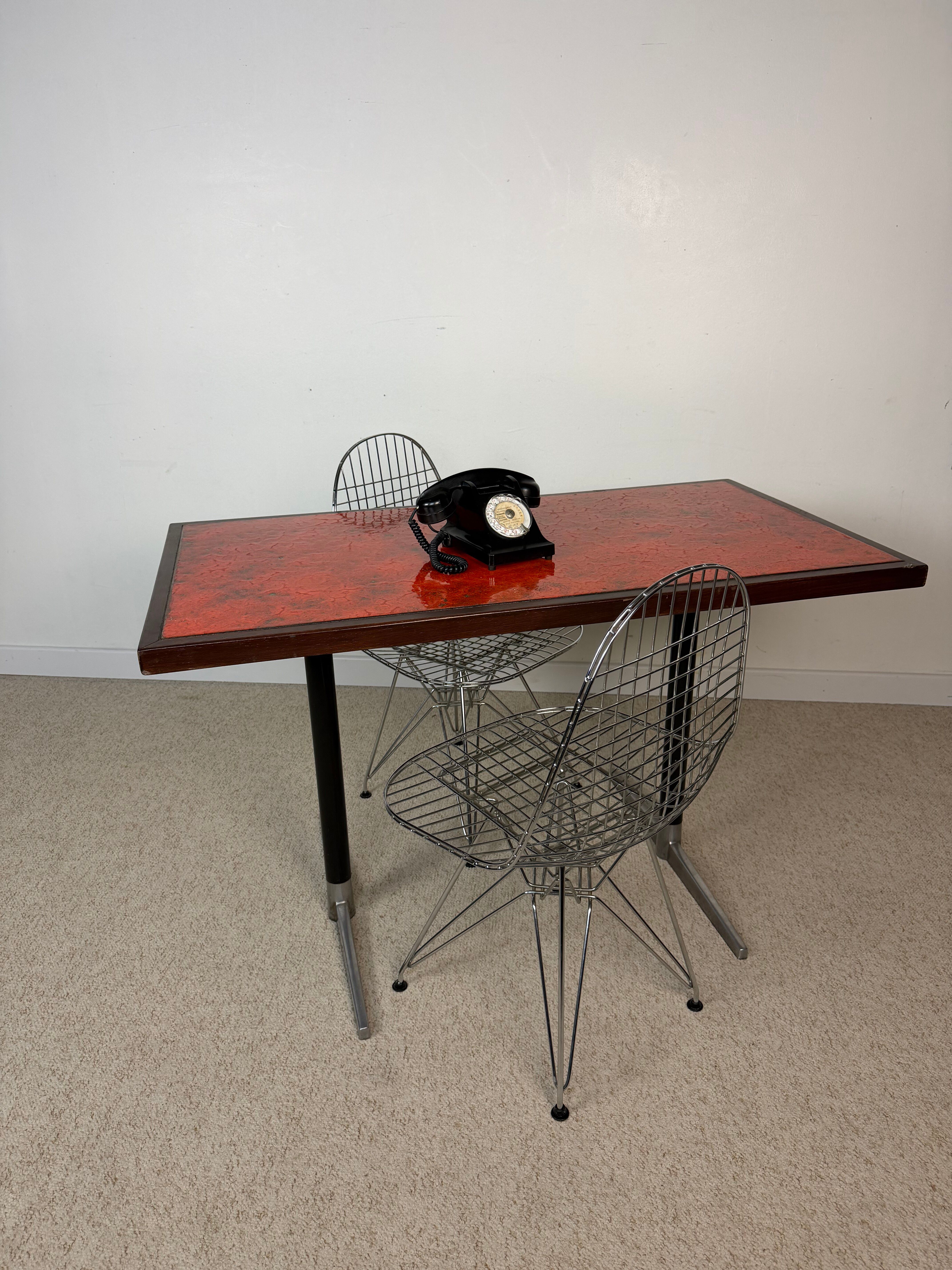 Vintage bistro table with orange-red ceramic.