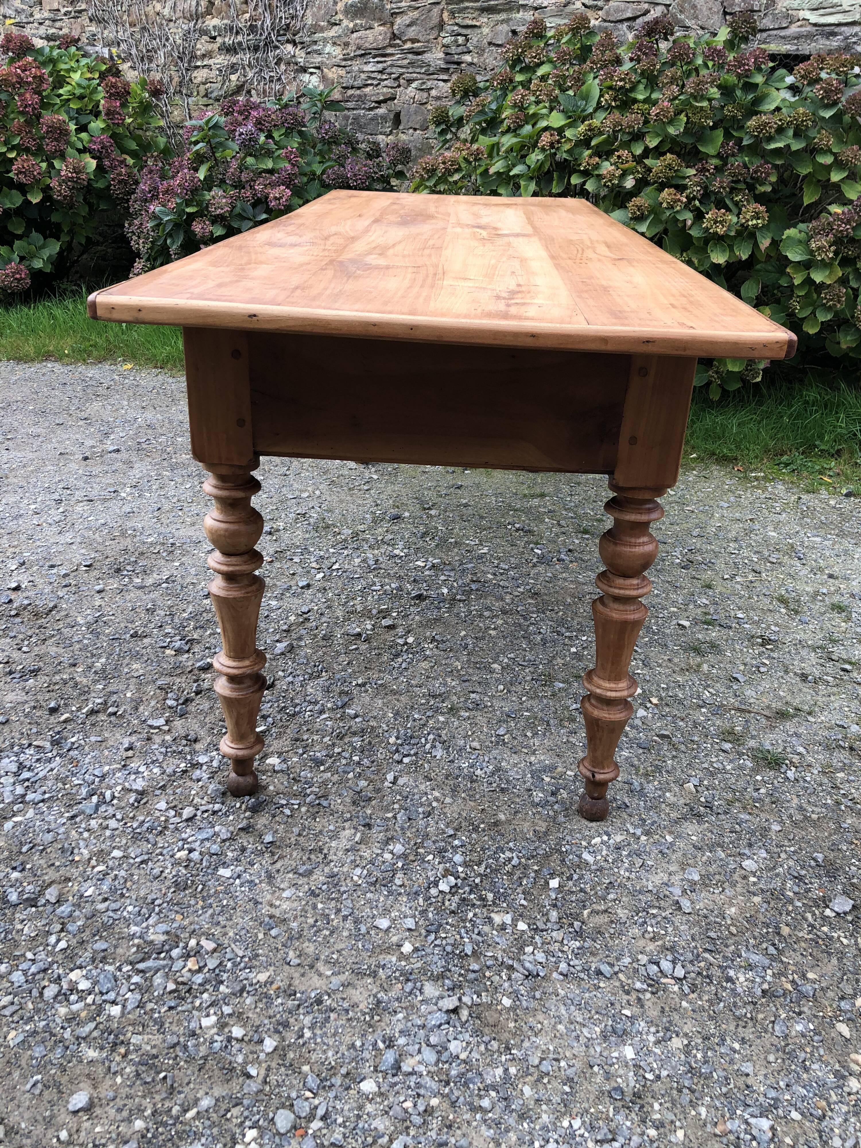 Antique Louis Philippe style farm table in solid cherry wood with 2 drawers and turned base.