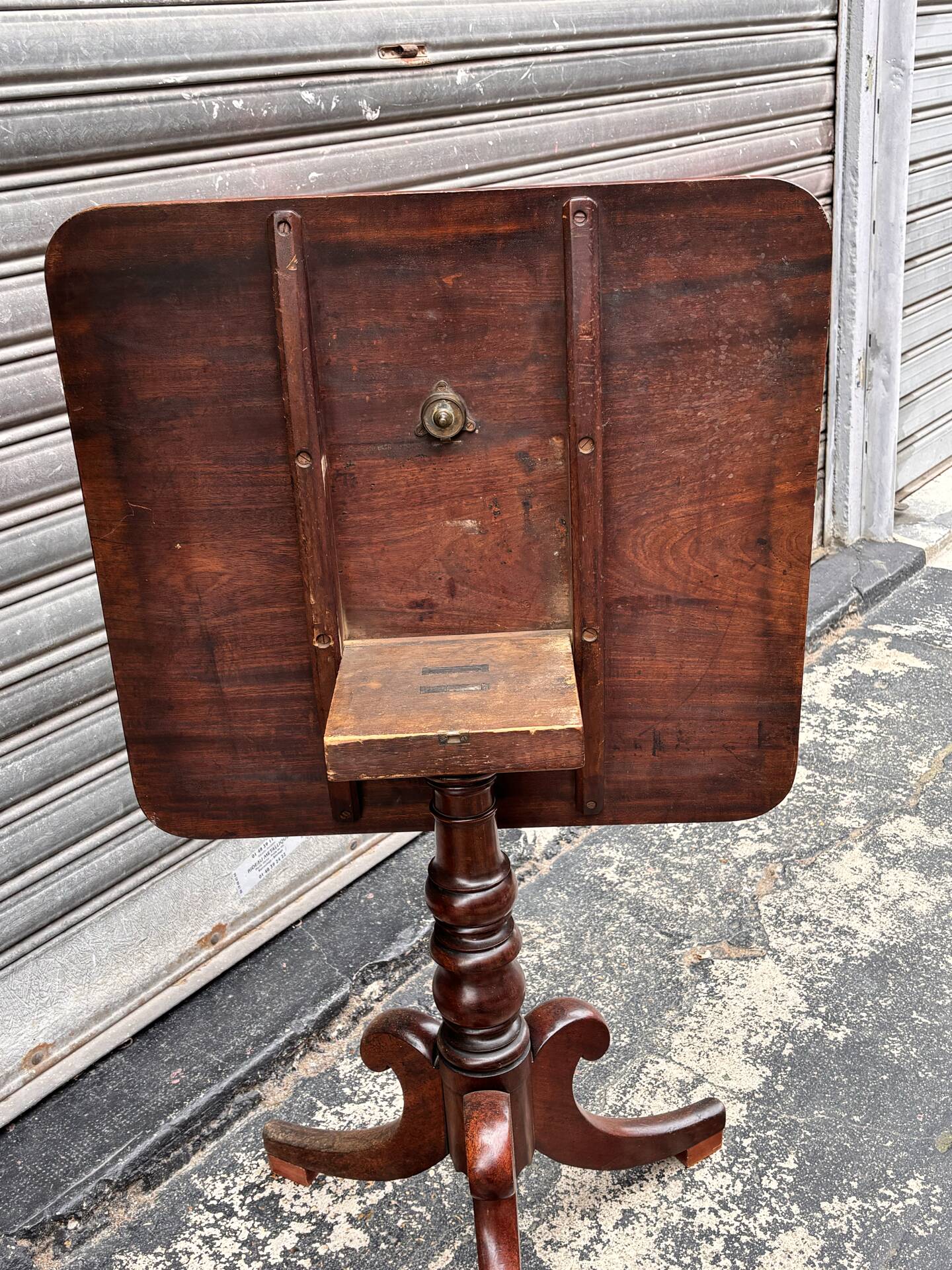 19th-century solid mahogany table with a tilting top and brass mechanism.