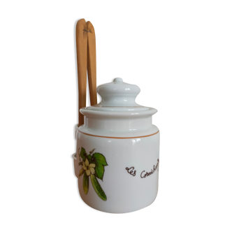 Vintage porcelain pickle pot with wooden pliers.