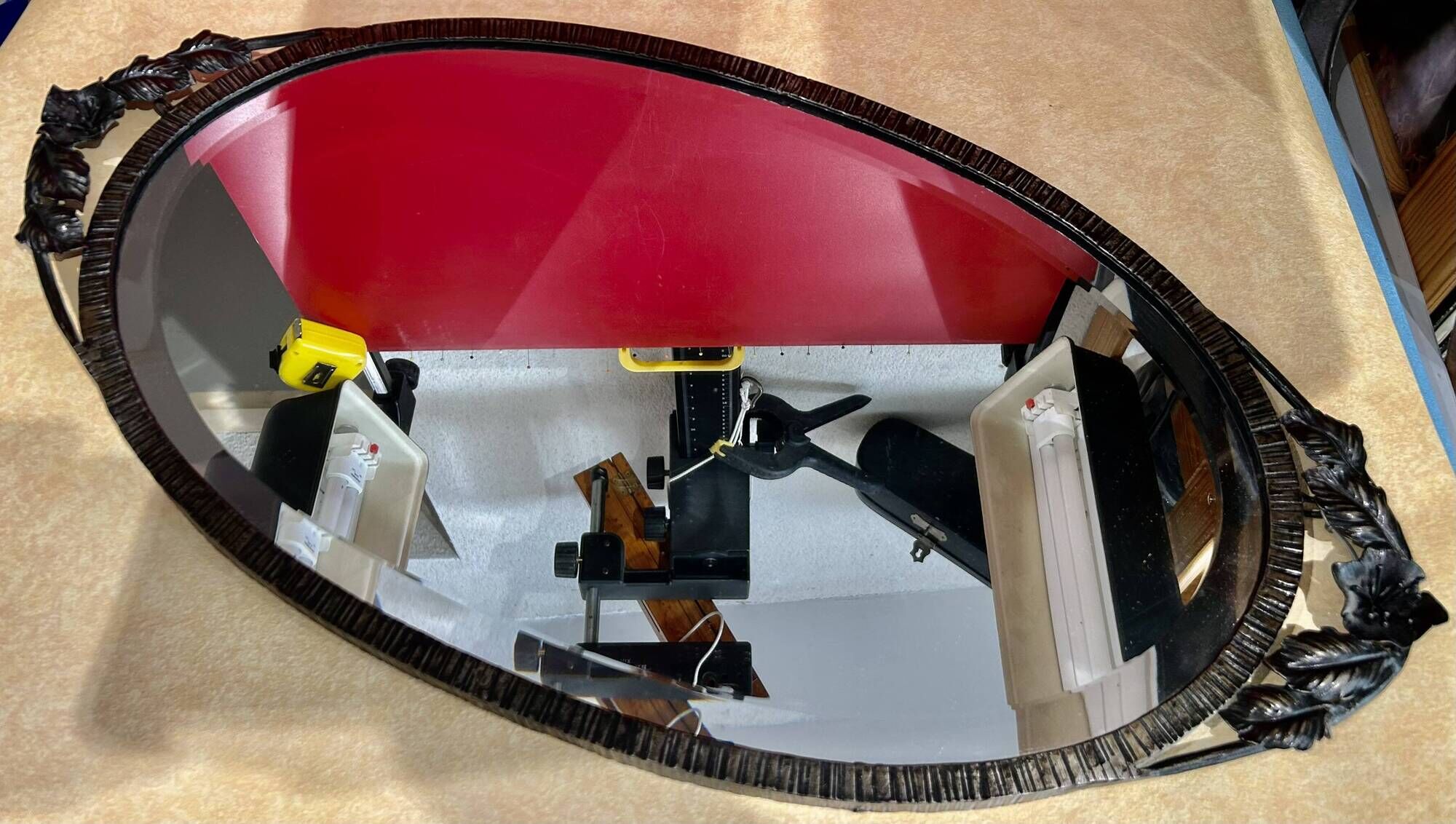 Bevelled oval mirror, richly crafted Art Deco wrought iron.
