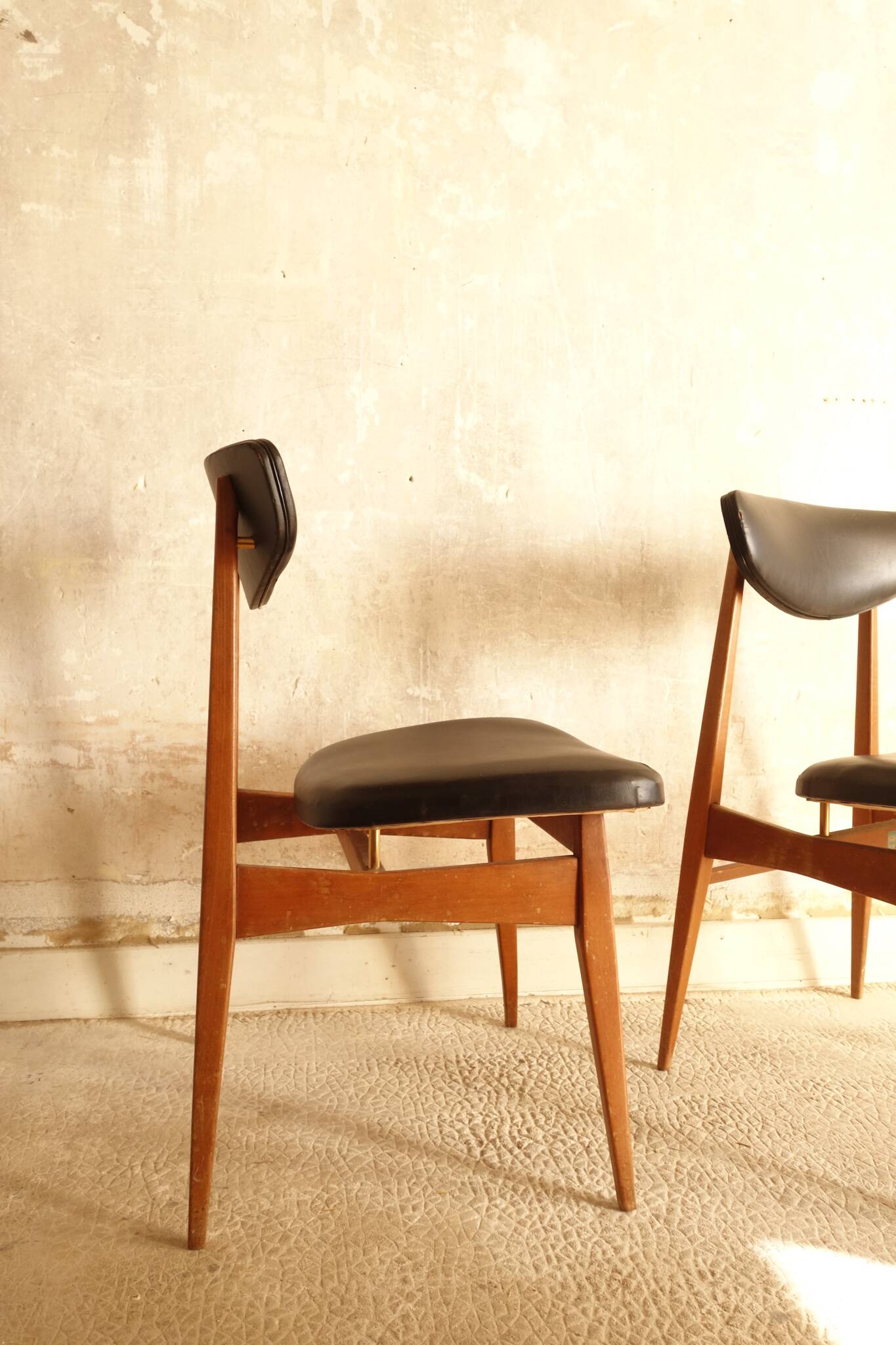 Pair of modernist Scandinavian chairs in teak and black faux leather.