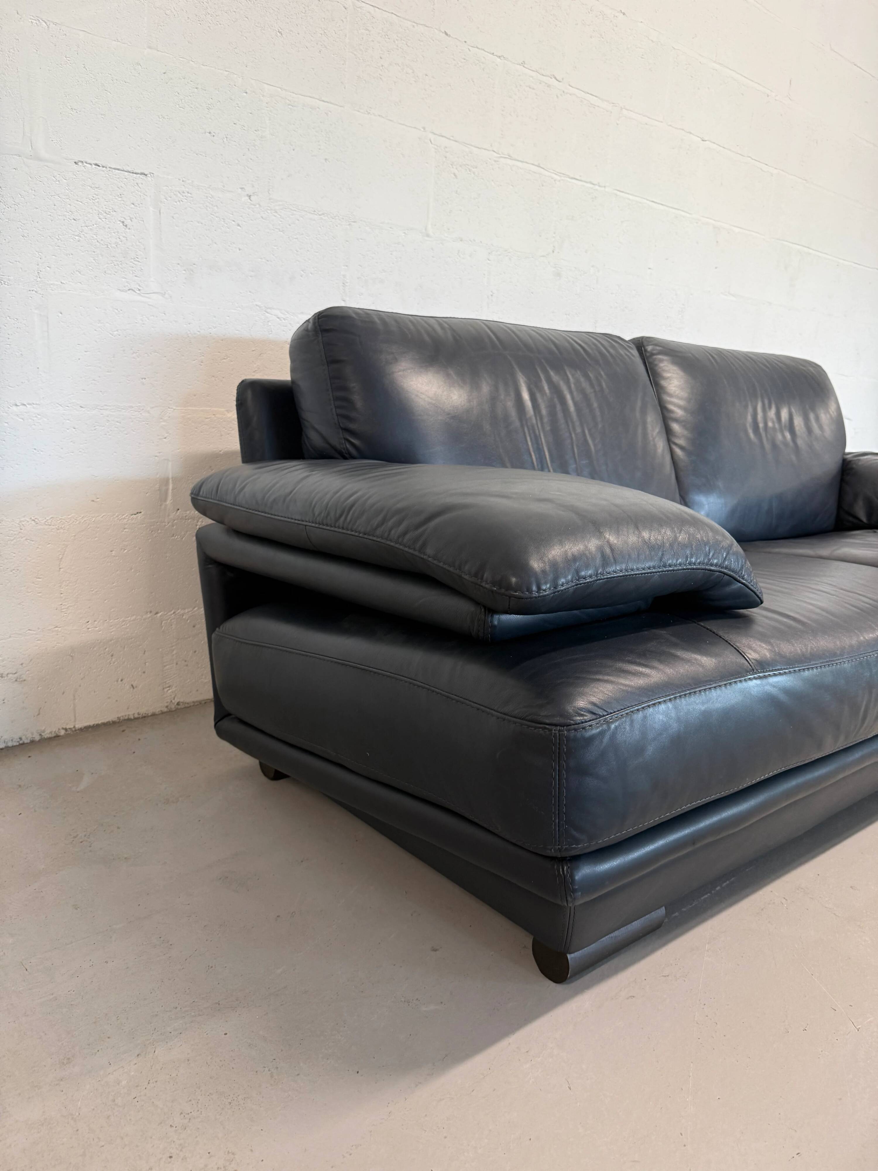 Two-seater Natuzzi sofa in navy blue leather.
