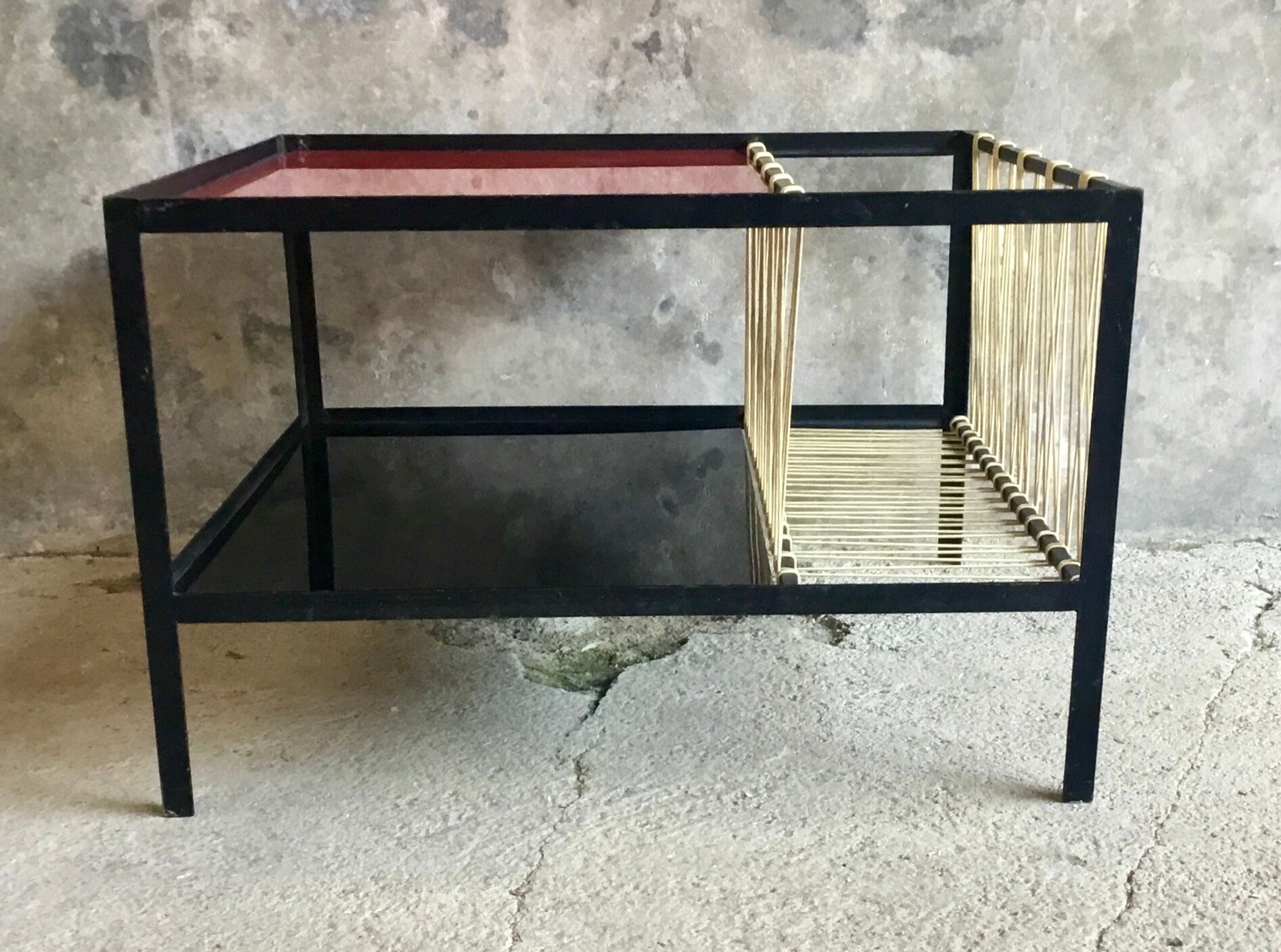 Modernist metal coffee table with a magazine rack in 1950s design.