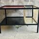Modernist metal coffee table with a magazine rack in 1950s design.