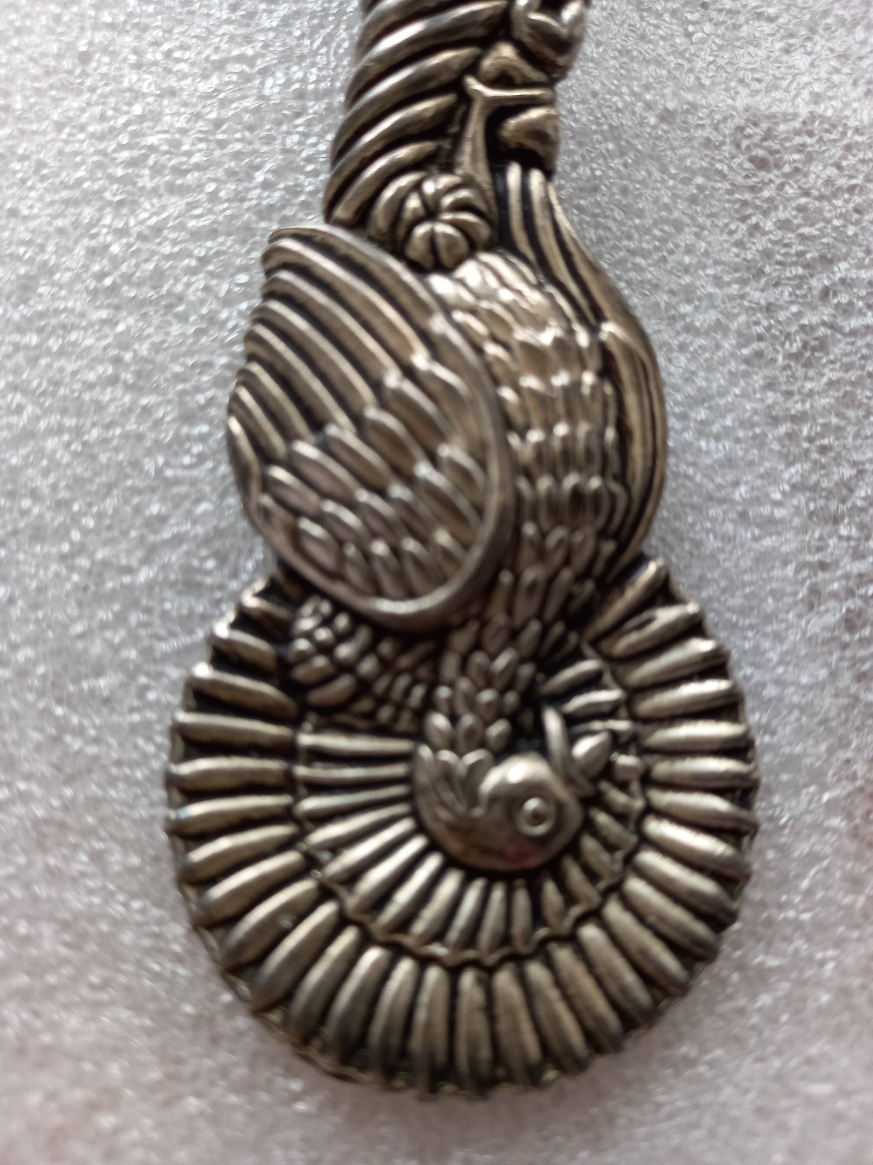 Vintage serving spoon with a carved relief handle.