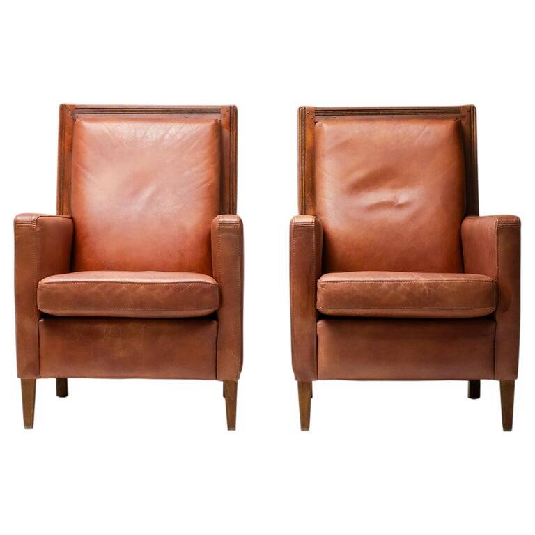 Pair of Art Deco armchairs in brown leather and teak, Netherlands, 1970s.