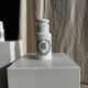 A pair of white glass bottles with Italian green patterns.