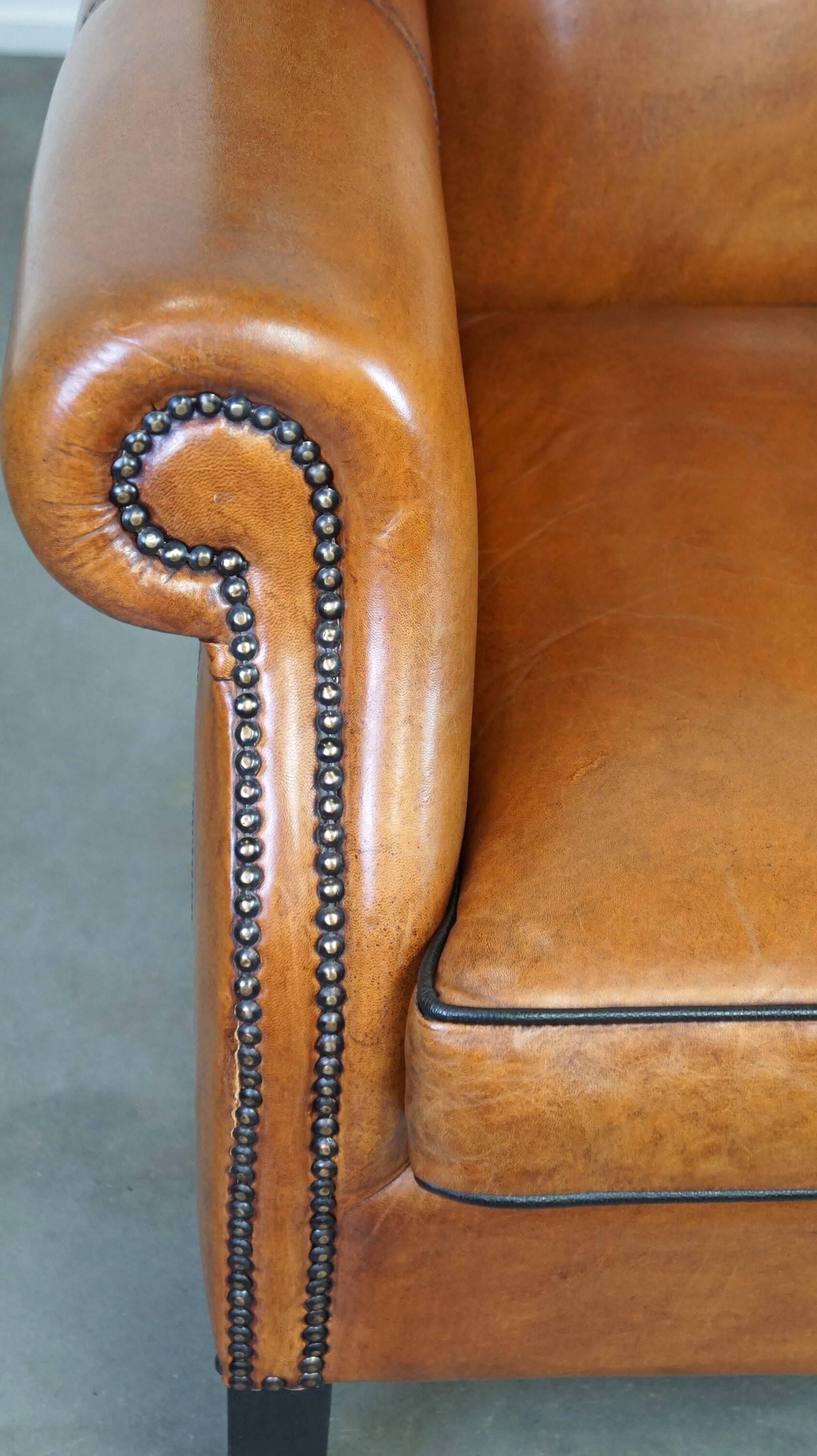 Très beau fauteuil à oreilles en cuir de mouton avec des détails époustouflants