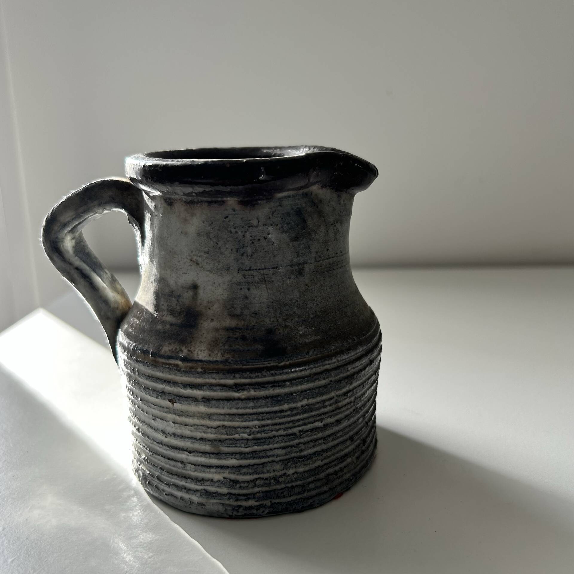 Patinated pitcher signed