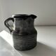 Patinated pitcher signed