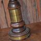 Vintage brown and gold desk lamp made of carved wood and brass, with a fringed shade.