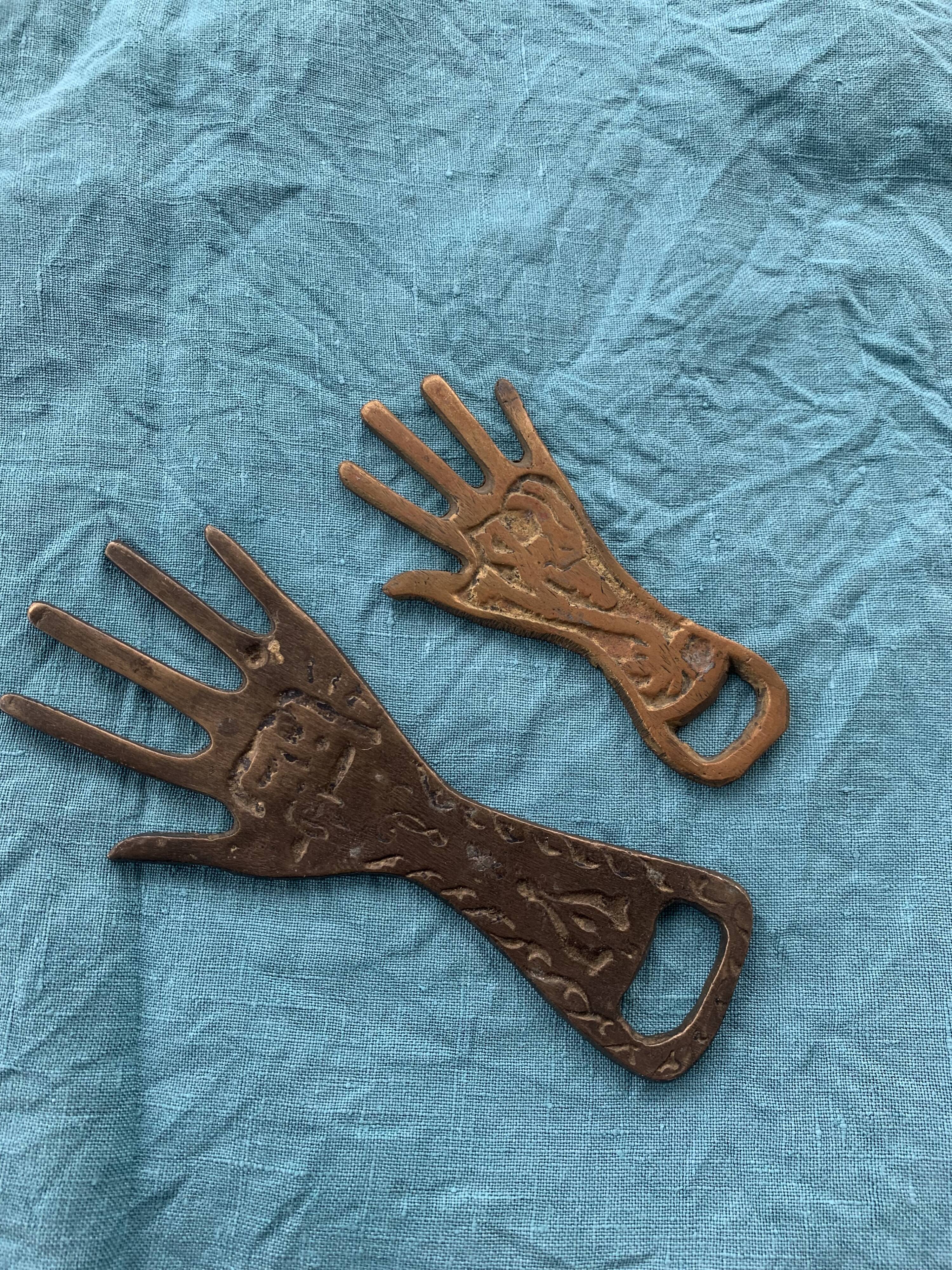 Two brass bottle openers in the shape of a chiseled hand vintage oriental décor
