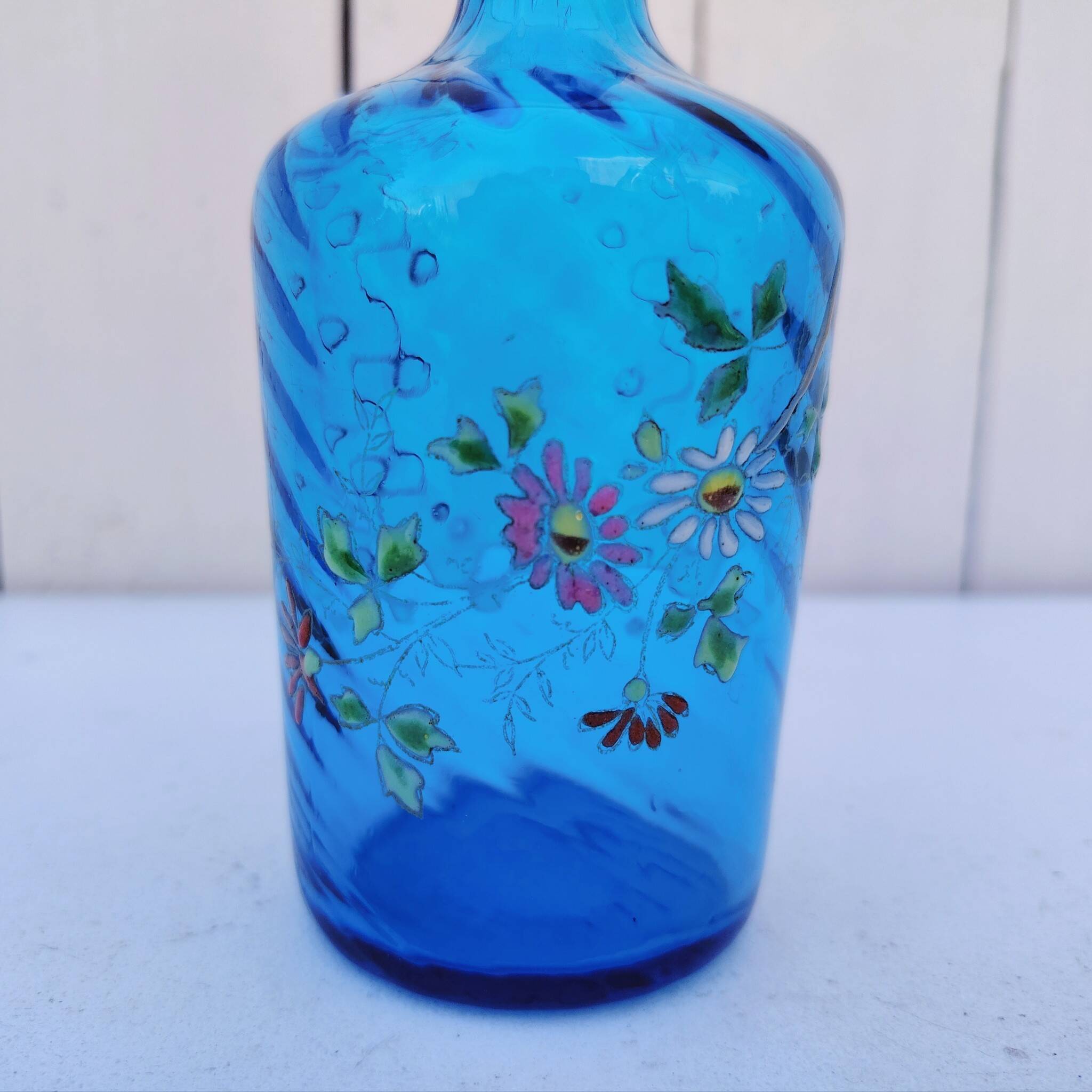 Vintage twisted blue glass carafe with enamel decoration.