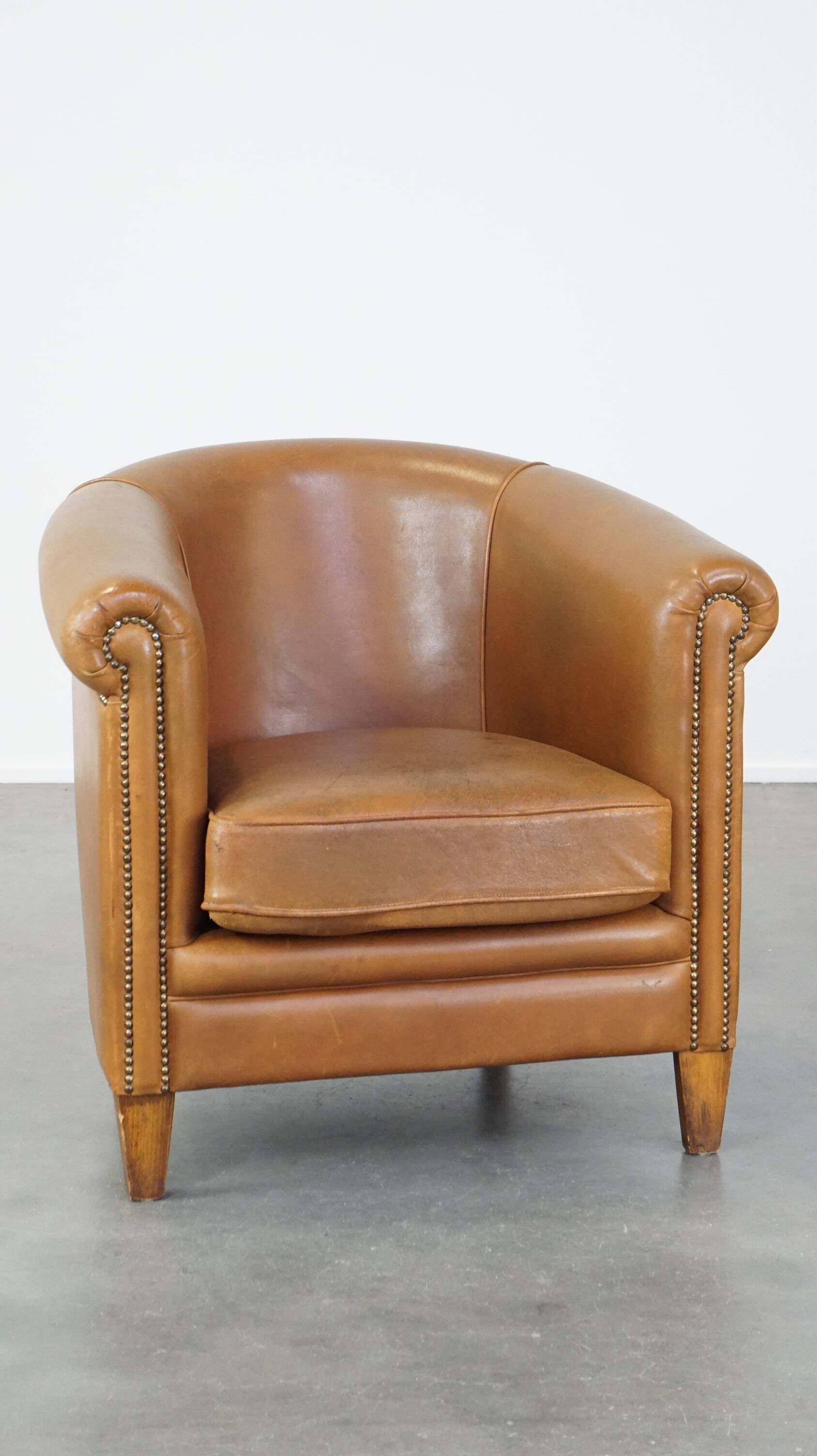Sheep leather club chair in neutral cognac colour and in good condition