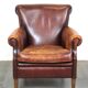 Fauteuil en cuir de mouton robuste et usé mais très confortable avec une belle patine