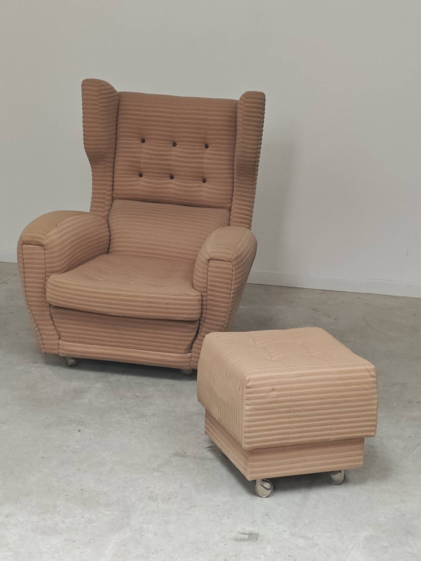 Beige wingback armchair and TVAR footrest, former Czechoslovakia.
