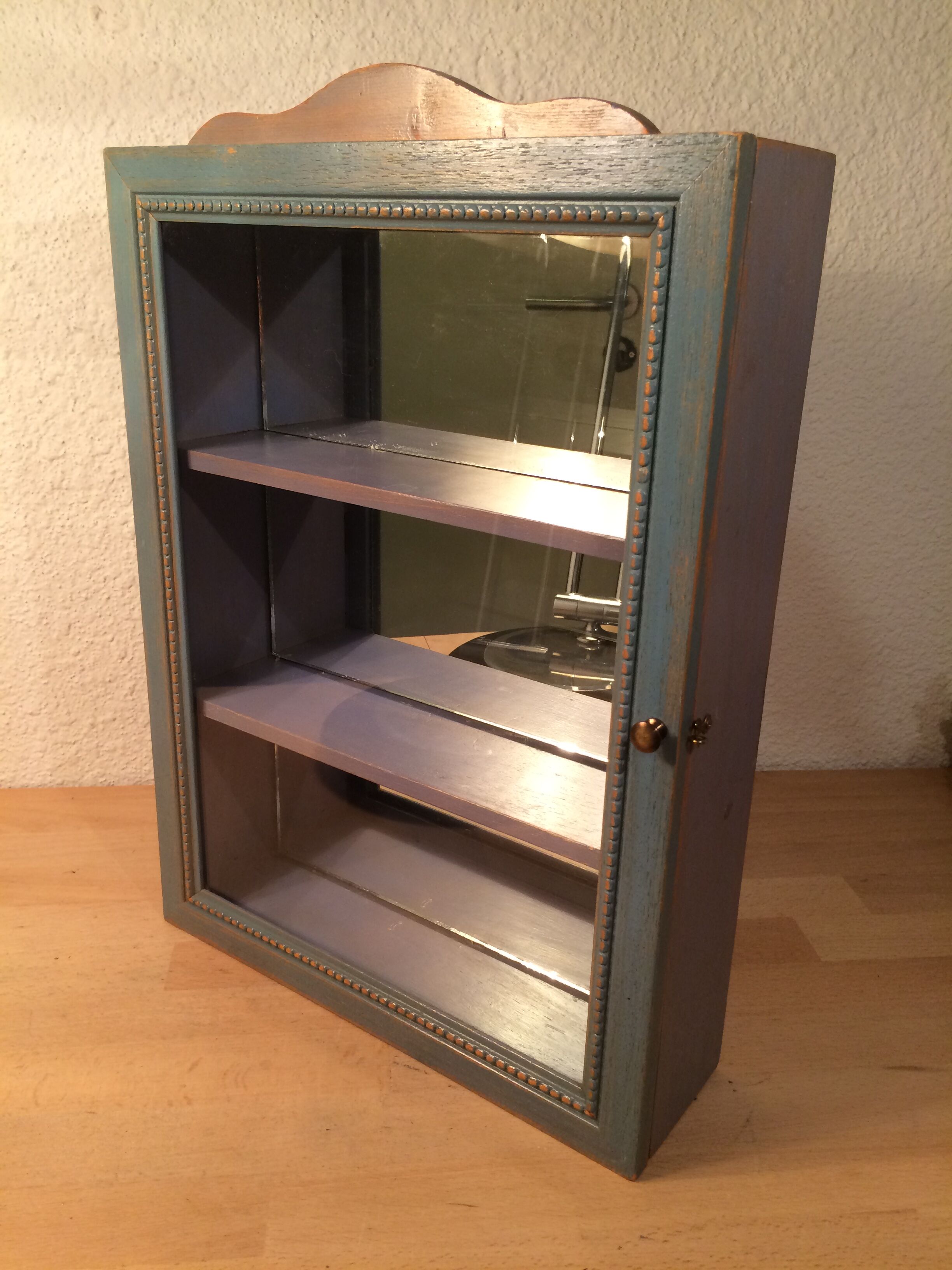 Display shelf with miniature blue wood and mirrors
