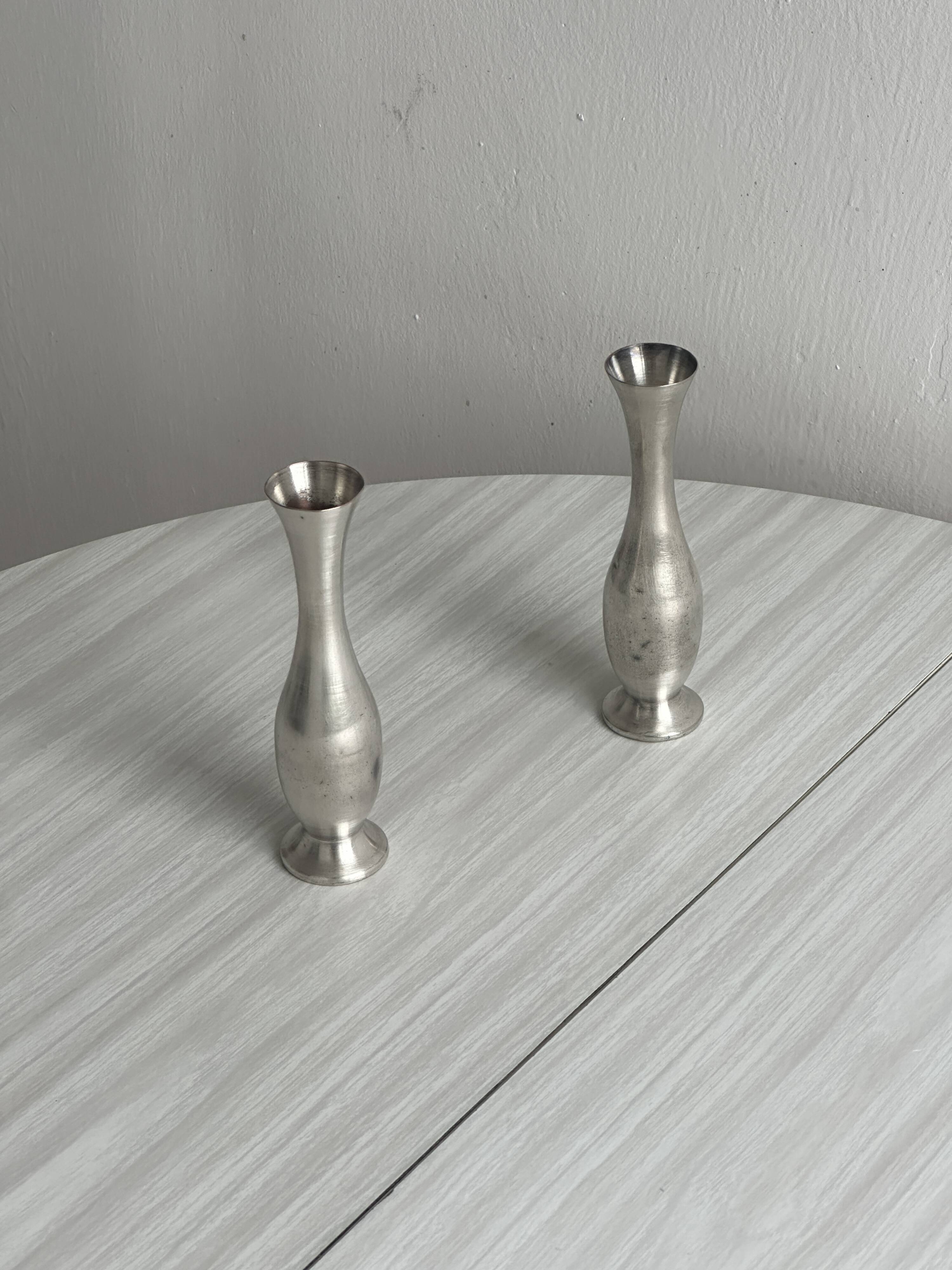2 shiny metal vases