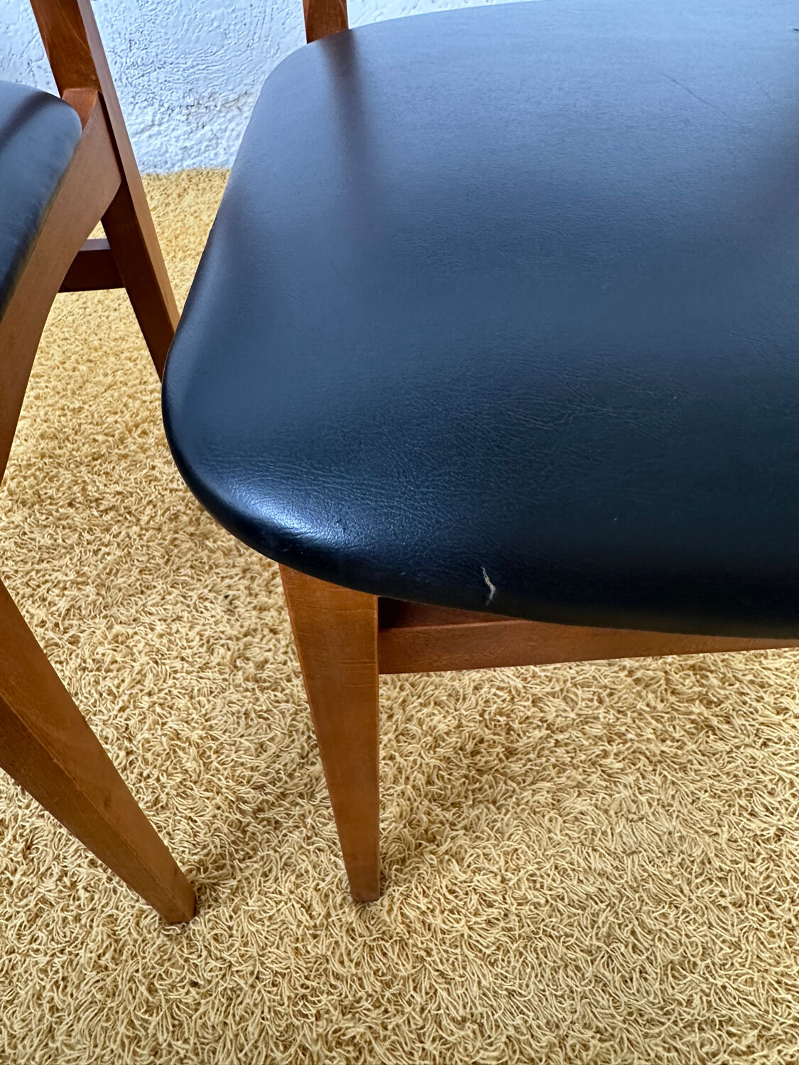 4 Scandinavian chairs in teak and black faux leather.