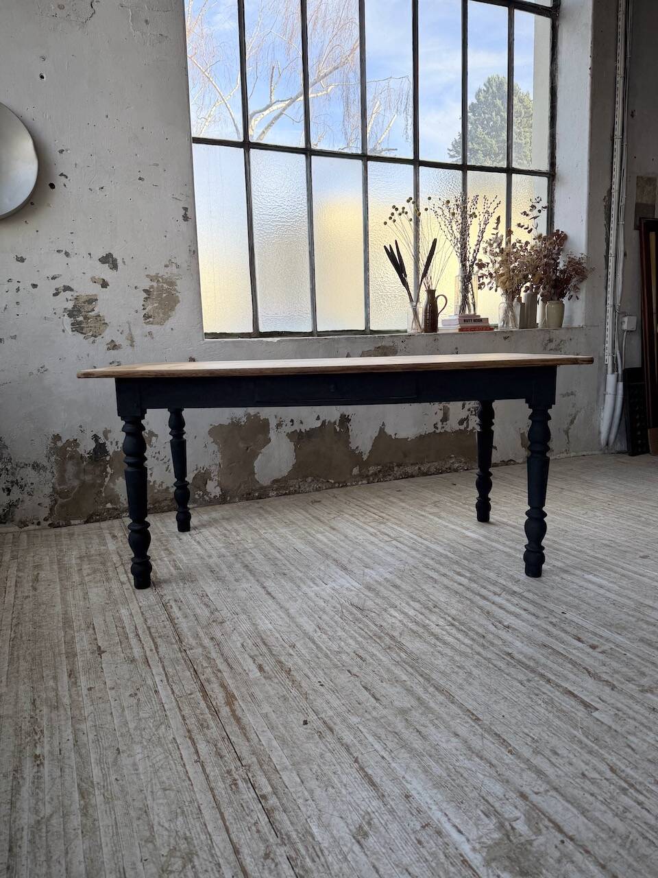 Oak farmhouse table with turned black legs.