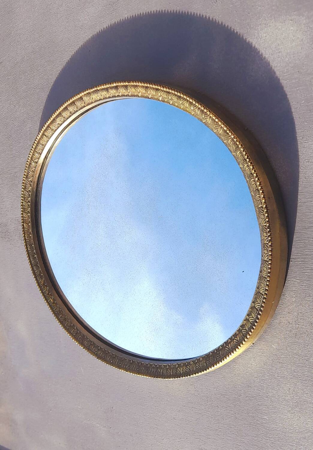 Oval mirror in gold metal