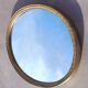 Oval mirror in gold metal