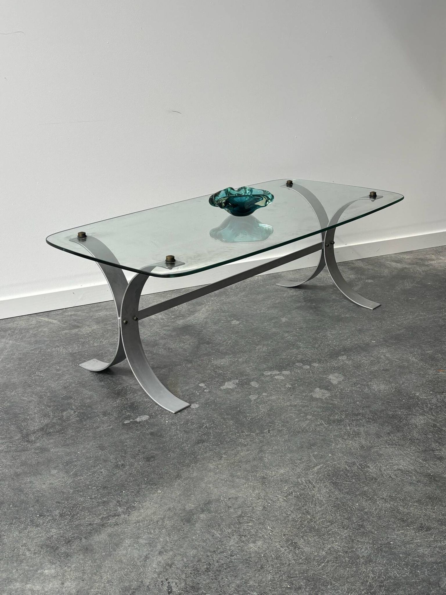 Design coffee table in brushed metal with a glass top, 1970s.