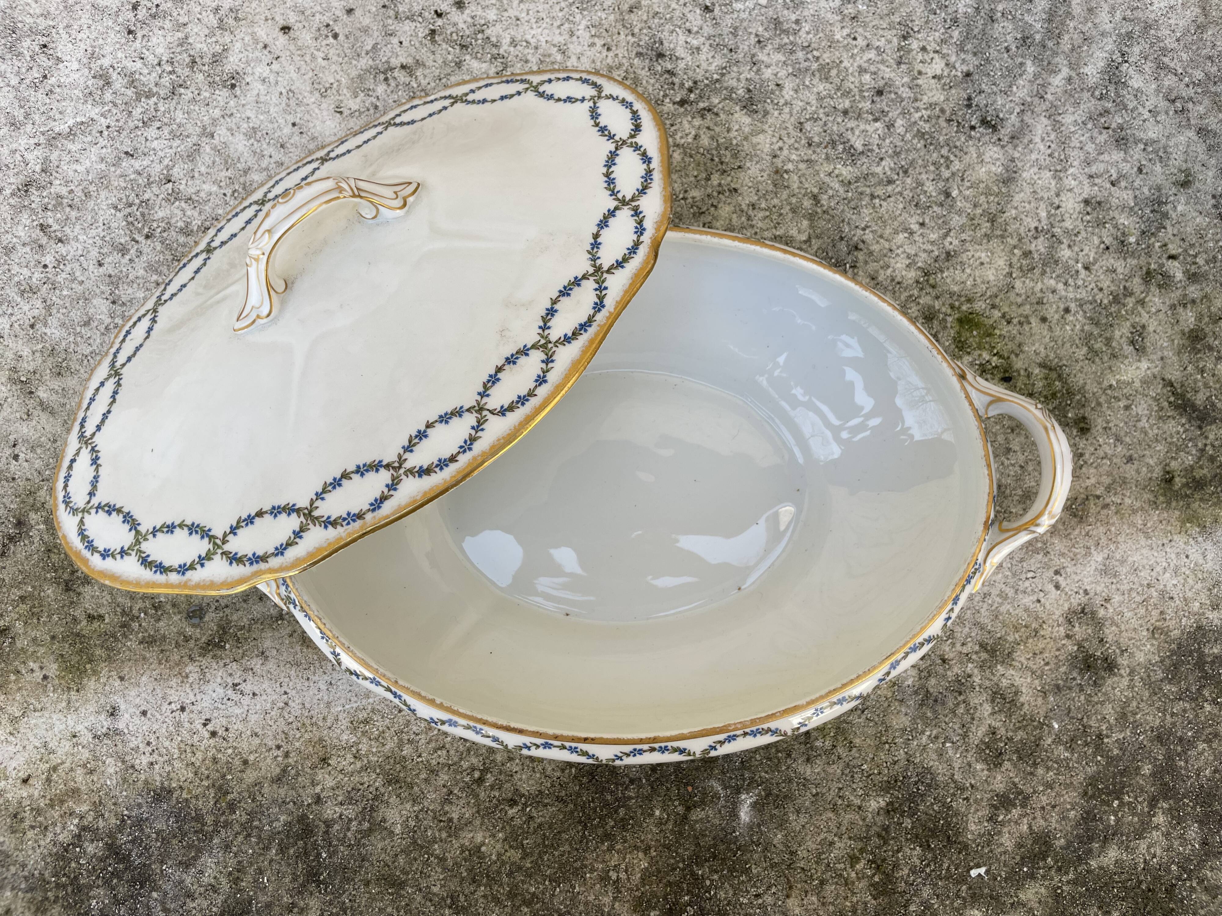 Old soup bowl with a golden border and decorated with small blue flowers