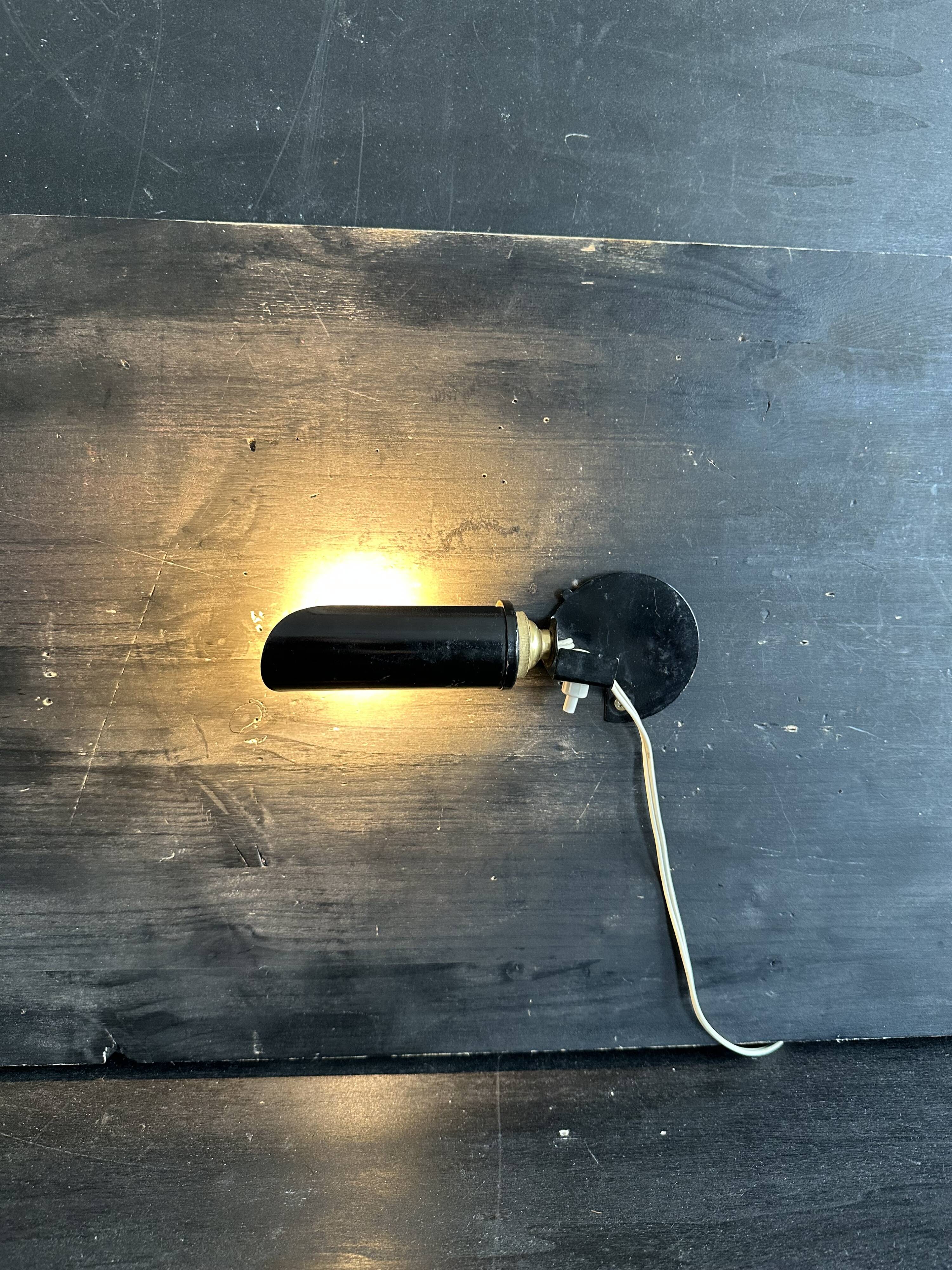 Old black metal and brass wall light, adjustable, 1930s.