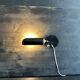 Old black metal and brass wall light, adjustable, 1930s.