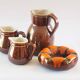 Duo of brown enamel pitchers
