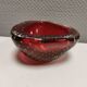 Small glass bowl in beautiful emerald red color with inlaid bubbles.