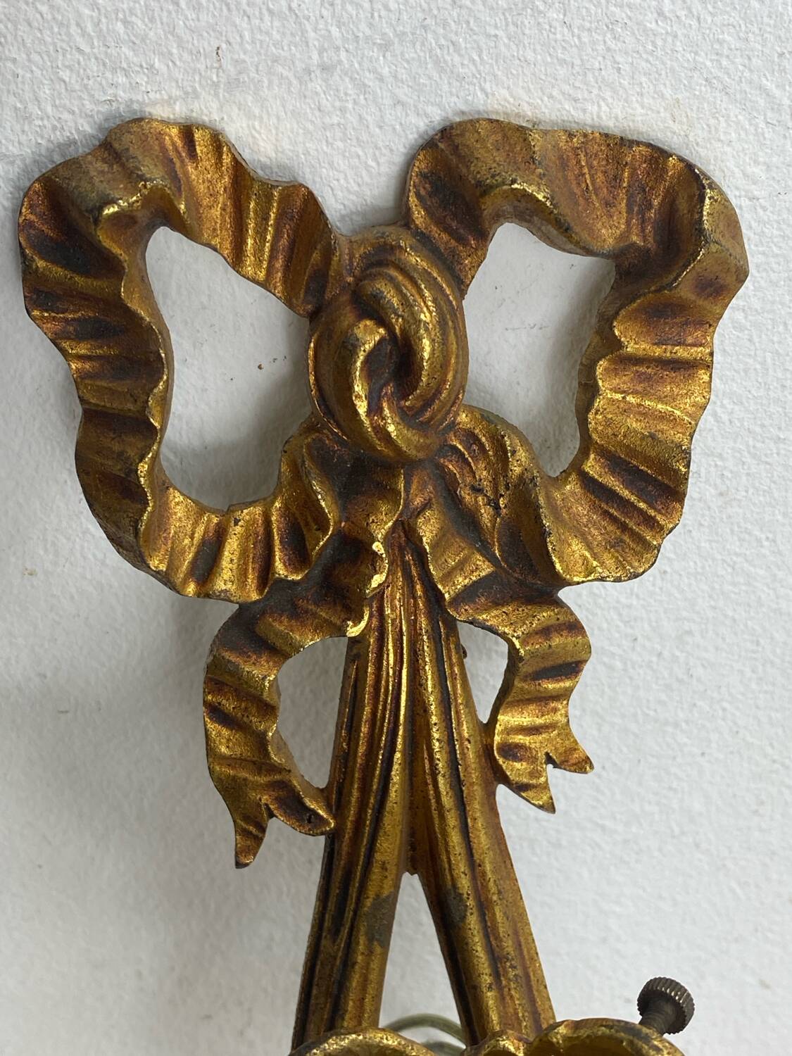 Bronze wall light, decorated with a bow and ribbon.