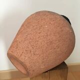 Terracotta vase with gradient of black faded to half on an earth-colored background