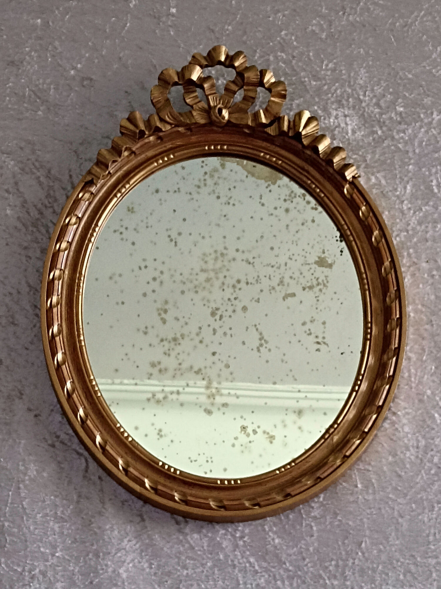 Oval mirror in carved and gilded wood in Louis XVI style