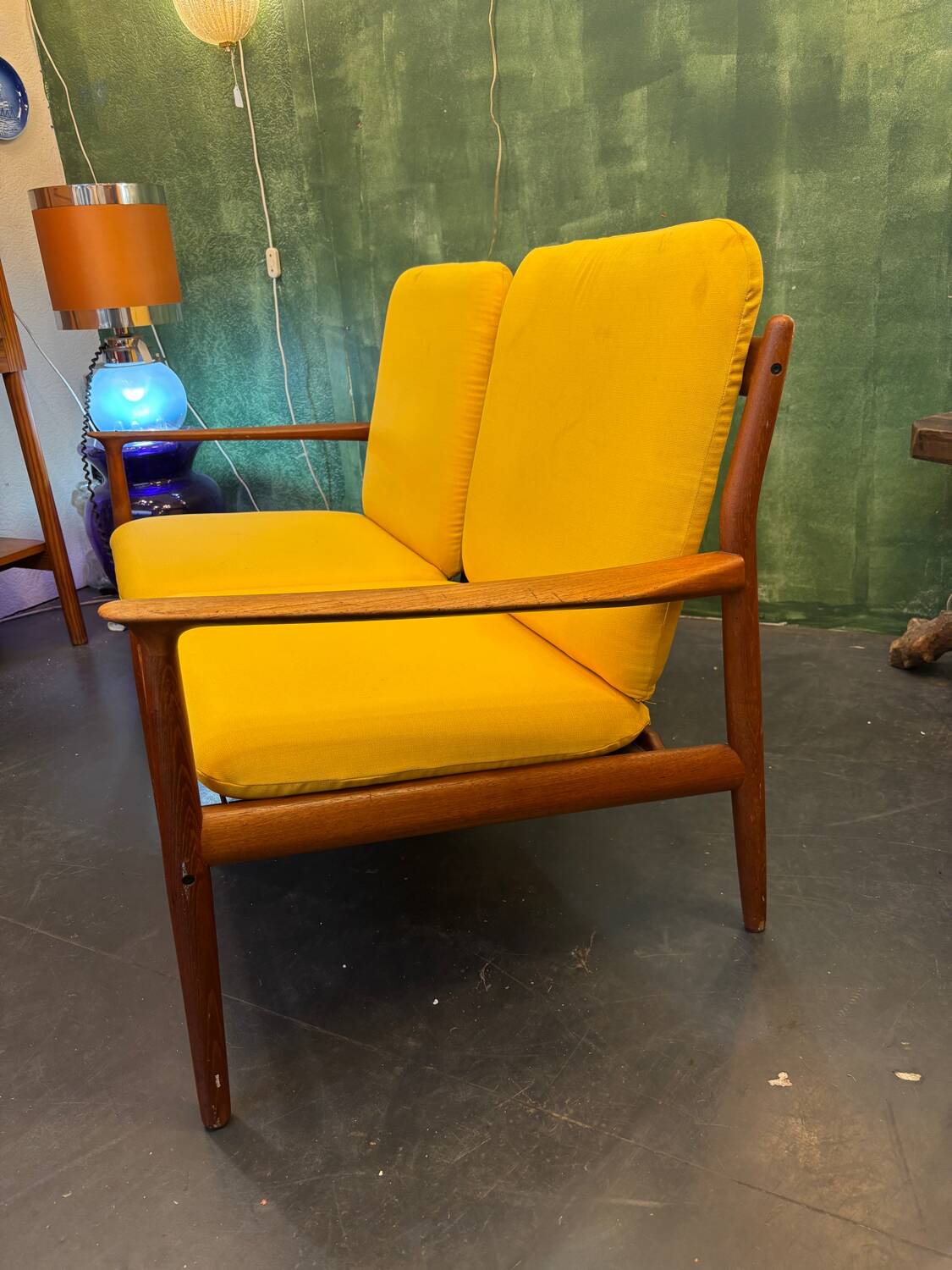 Vintage Scandinavian two-seater bench with mustard yellow cushions.