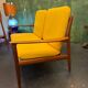 Vintage Scandinavian two-seater bench with mustard yellow cushions.