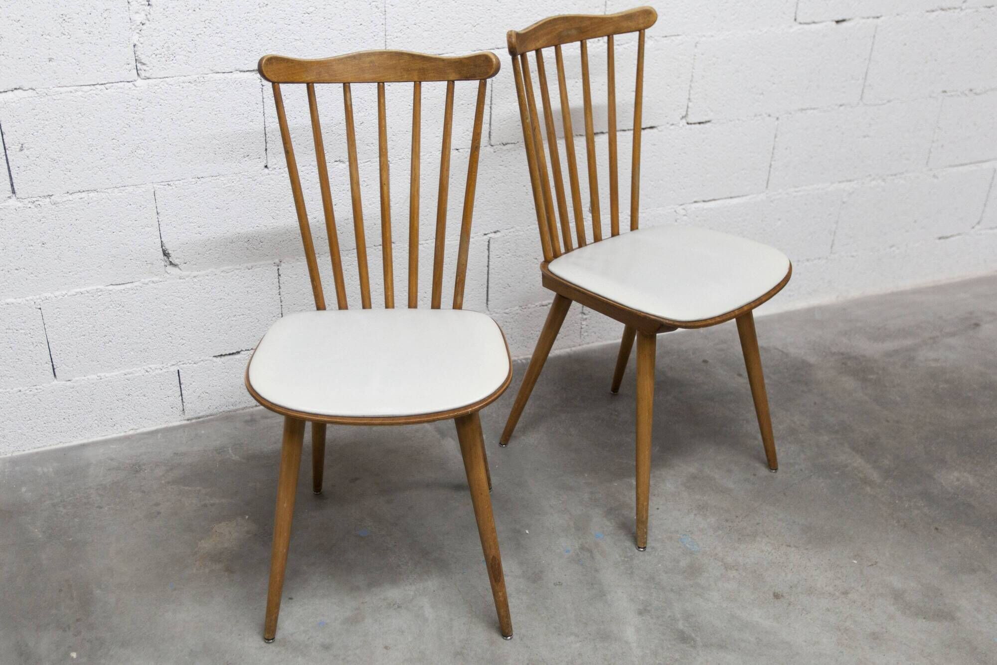 Pair of Baumann Menuet chairs, Honey patina, White skai seat