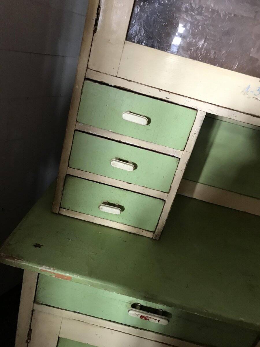 Vintage wooden kitchen cupboard painted green and beige, with glass doors - 1930s