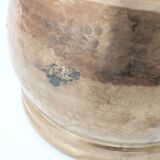 Vintage round cache-pot in hammered brass with decorative handles and patina.