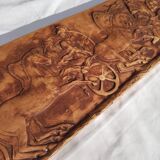 Bas-relief plaster scene of horses and a cart.