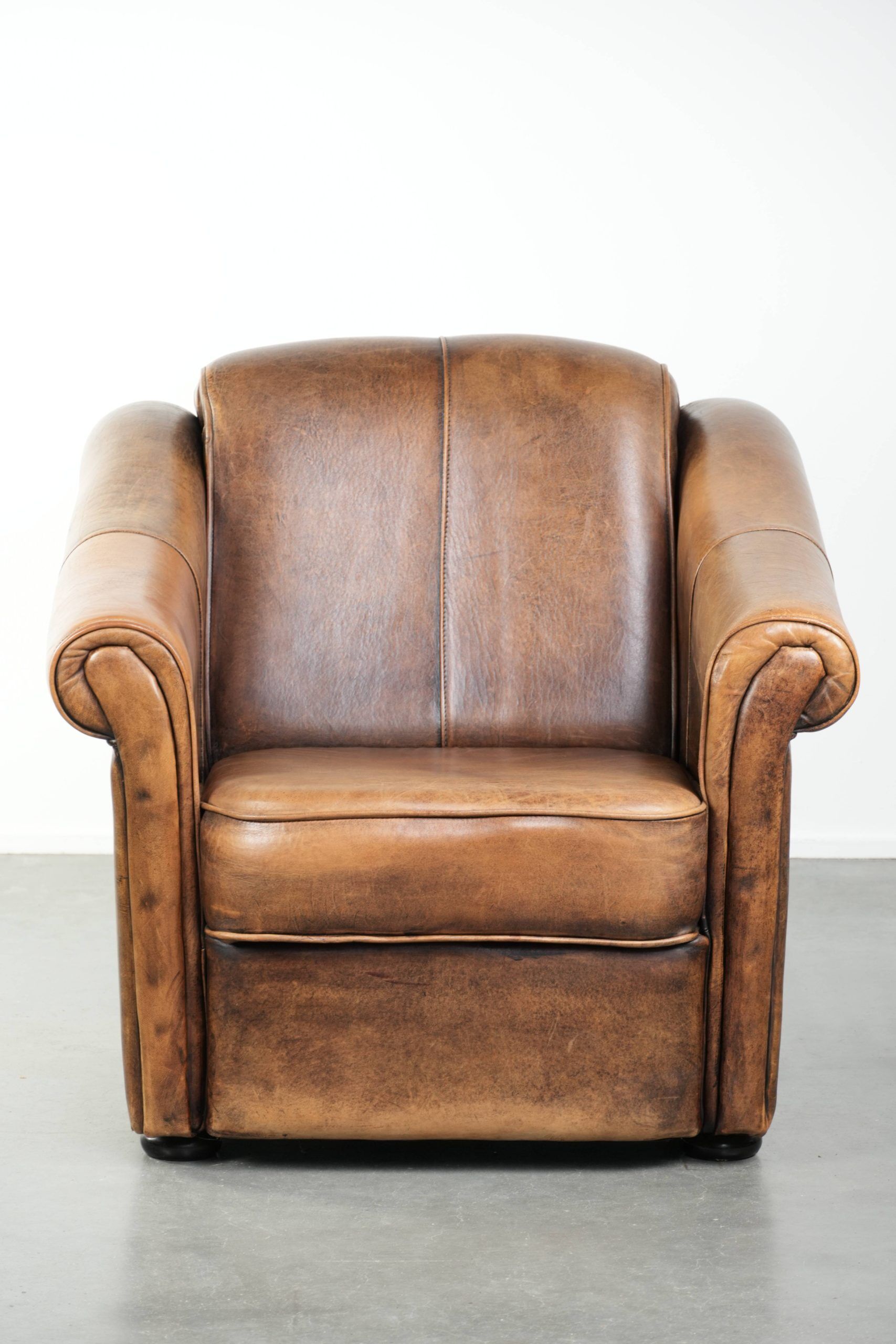 Fauteuil en peau de mouton magnifiquement conçu et confortable, avec un look intemporel et une finition de passepoil assortie.